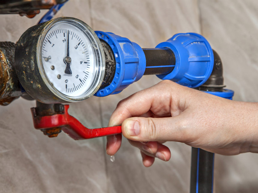 Image of a person adjusting a backflow prevention device